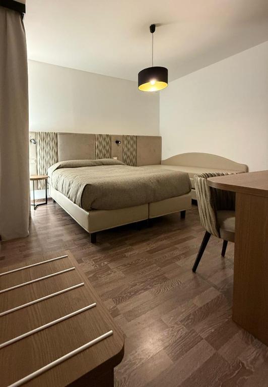 a bedroom with a large bed and a table at Hotel Miramare in Pineto