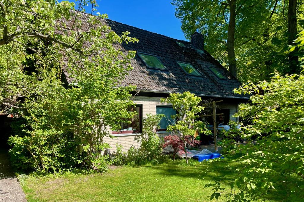 een wit huis met een zwart dak en een tuin bij Chez Lana in Berlijn