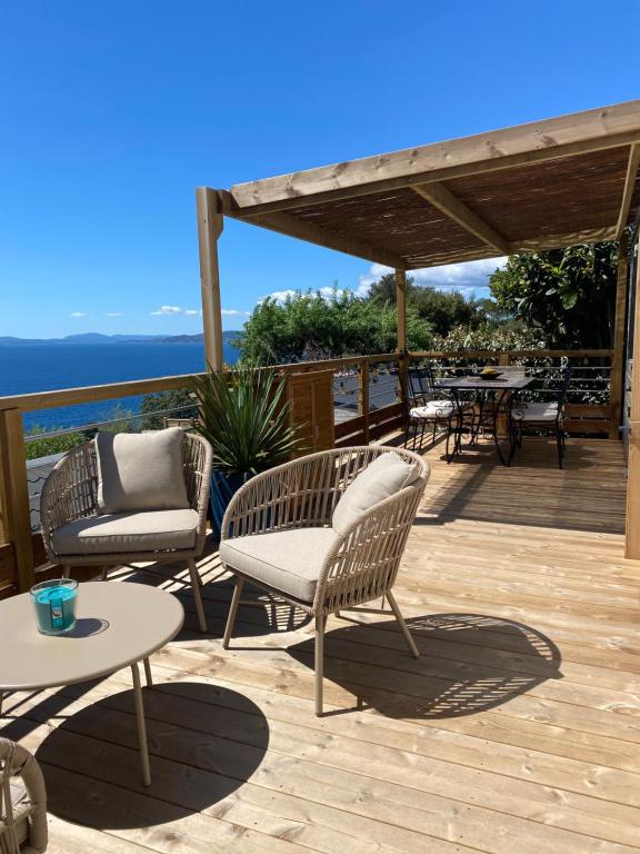 d'une terrasse avec des chaises et des tables. dans l'établissement Mobilehome Balzac 2 -3ch-Magnifique Vue mer, à Saint-Raphaël
