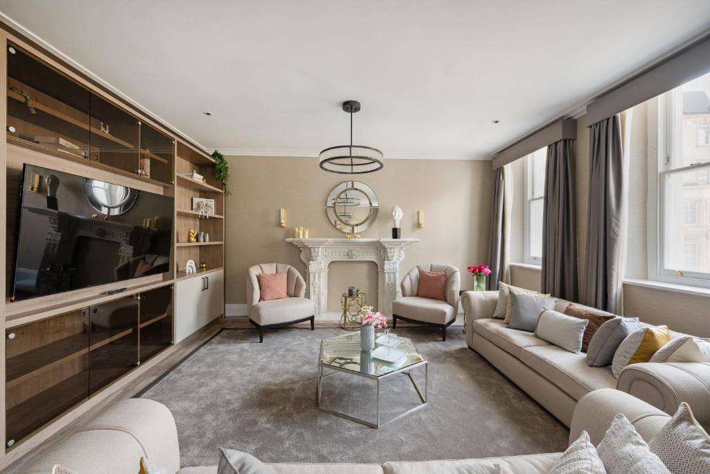 a living room with a couch and a fireplace at Charles of Mayfair in London