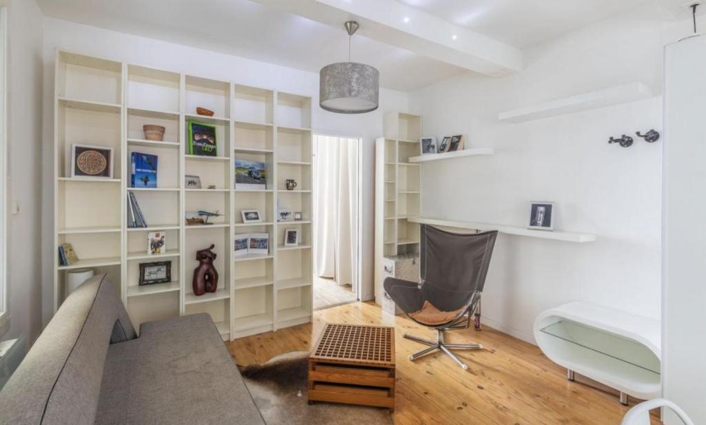 un salon avec un canapé et un bureau dans l'établissement Beautifully renovated 17th Paris apartment, à Paris