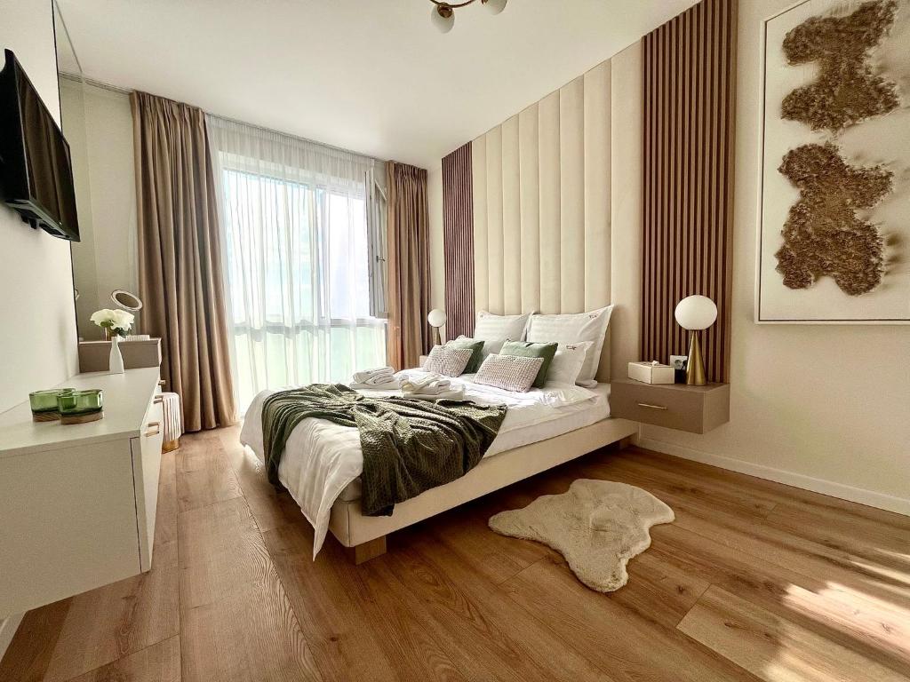 una camera da letto con un letto e una grande finestra di FLH - Golden Gallery Balcony Free Parking Vivo Mall Amethyst a Floreşti