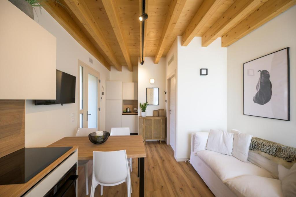 a living room and dining room with a couch and a table at La Còrt Apartments - Number 2 in Manerba del Garda