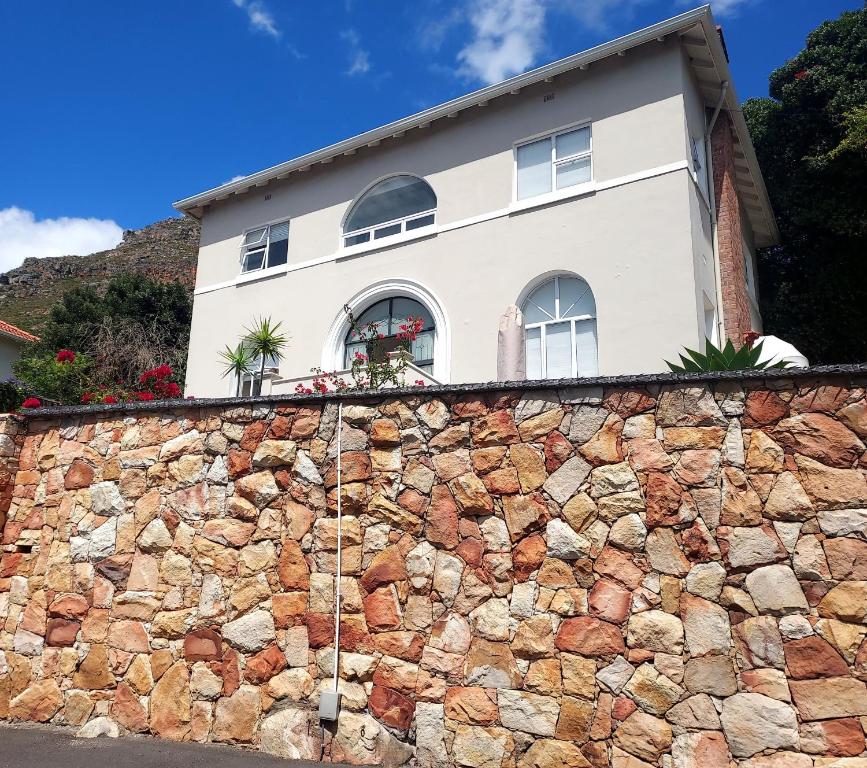 una casa en la parte superior de una pared de piedra en Penrose House Ocean View Villa, en Muizenberg