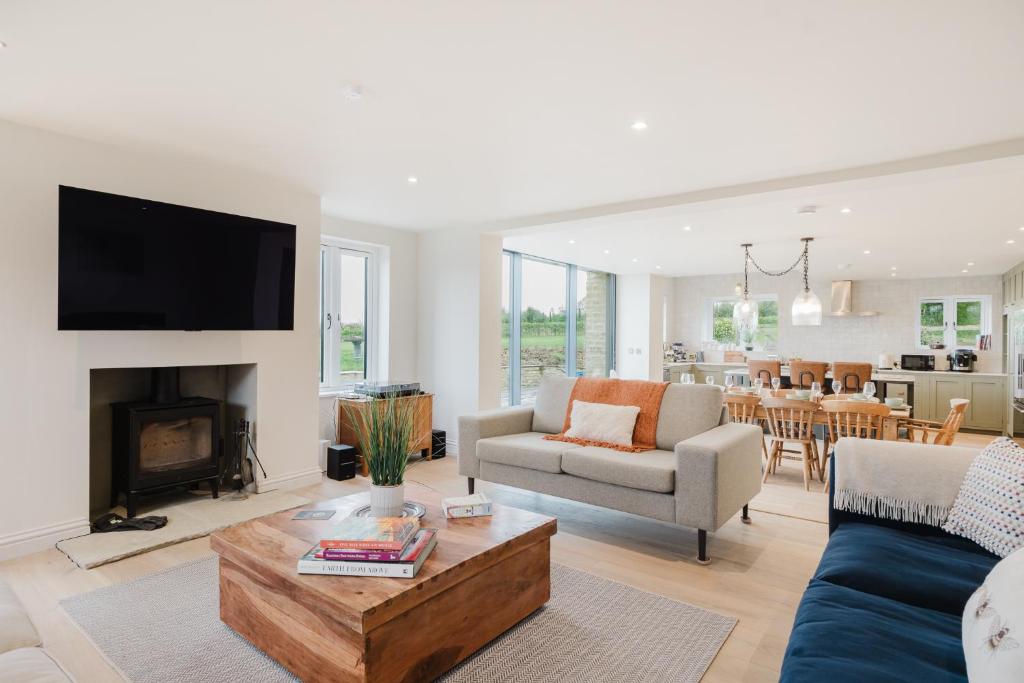 ein Wohnzimmer mit Sofa und Tisch in der Unterkunft Mulberry Cottage - Stunning 5 Bed in Wiltshire! in Charlton