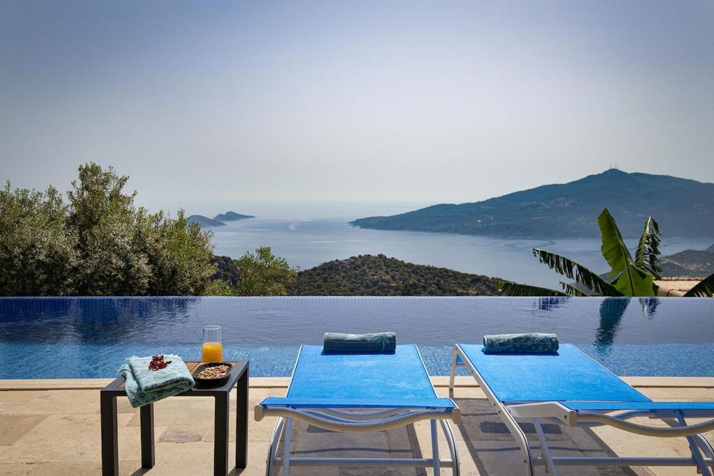two chairs and a table next to a swimming pool at Villa Upper House in Kas