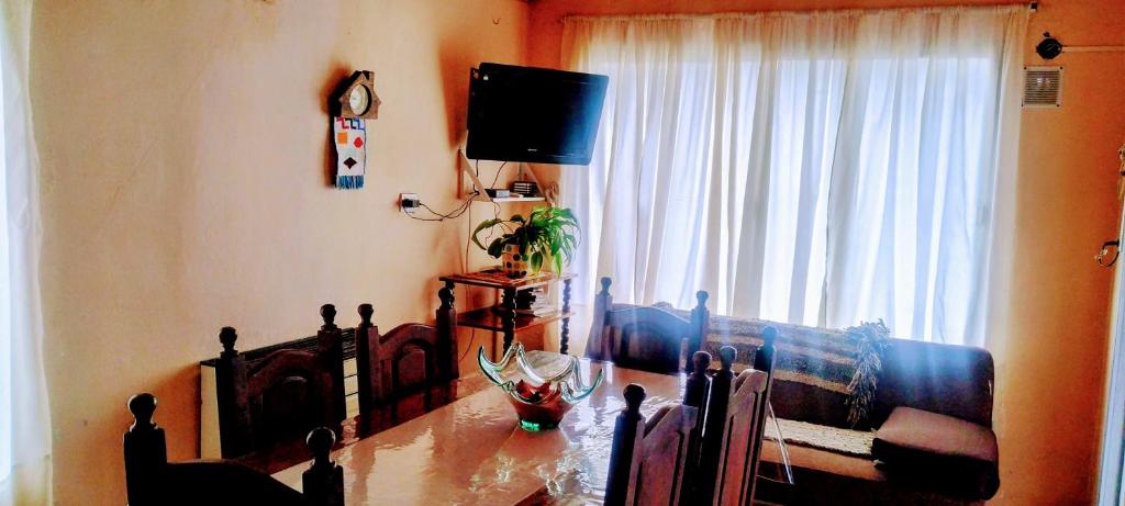 ein Wohnzimmer mit einem Tisch vor einem Fenster in der Unterkunft Alojamiento FARAH in Caviahue