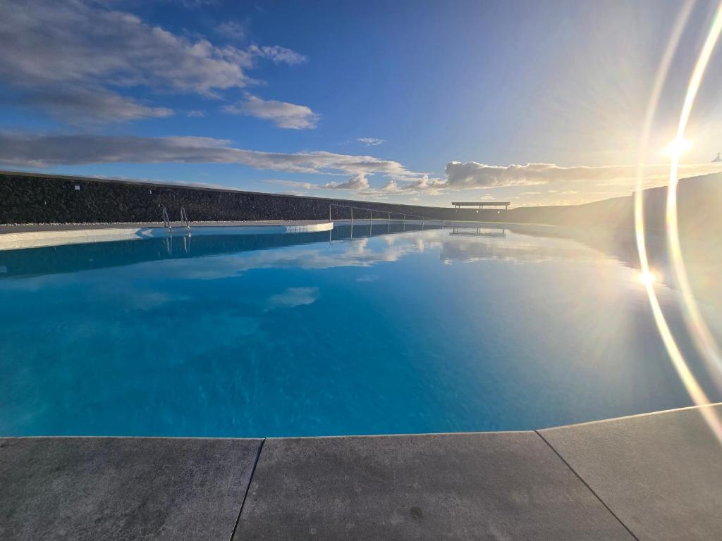 Una gran piscina con el sol en el cielo. en VV Milenaiver "by henrypole home", en Los Cancajos
