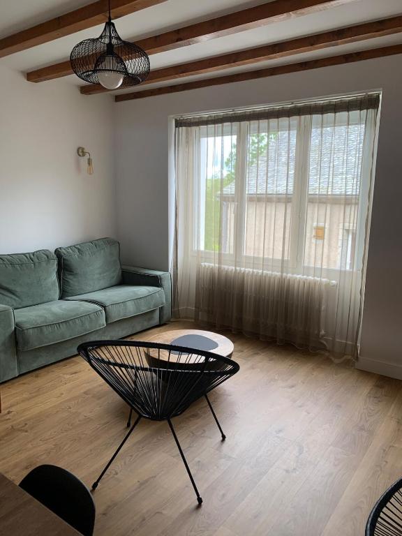 un salon avec un canapé et une table dans l'établissement Les fleurs d Aubrac, à Nasbinals