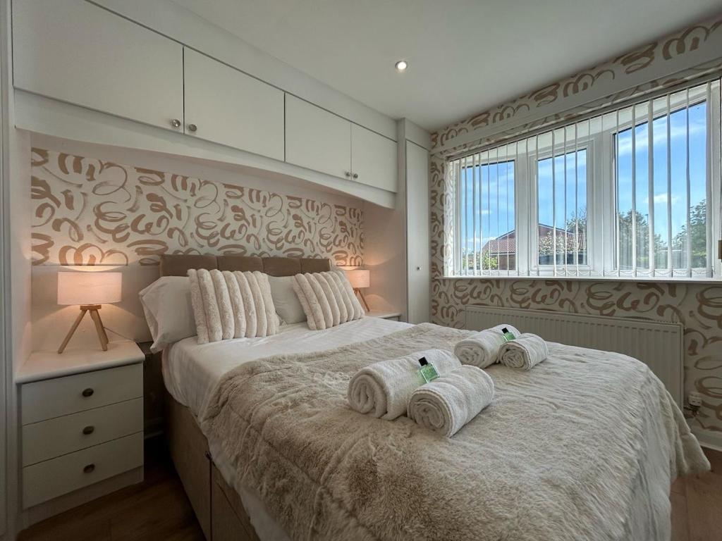 a bedroom with a large bed with towels on it at Modern 2 Bedroom Home in Kinmel Bay