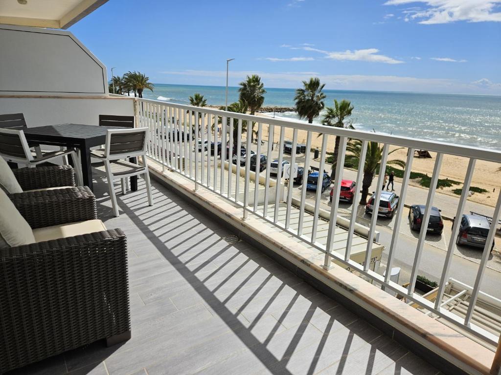 un balcon avec une table et des chaises et la plage dans l'établissement Apartamento moderno na praia com varanda grande, à Quarteira
