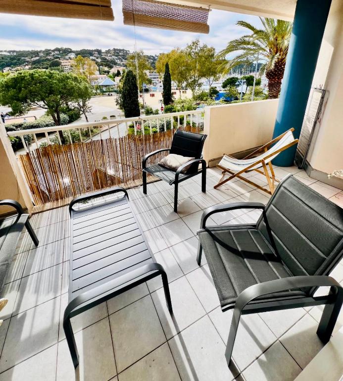 a balcony with chairs and a bench on a balcony at Superbe appartement bord de mer in Saint-Mandrier-sur-Mer
