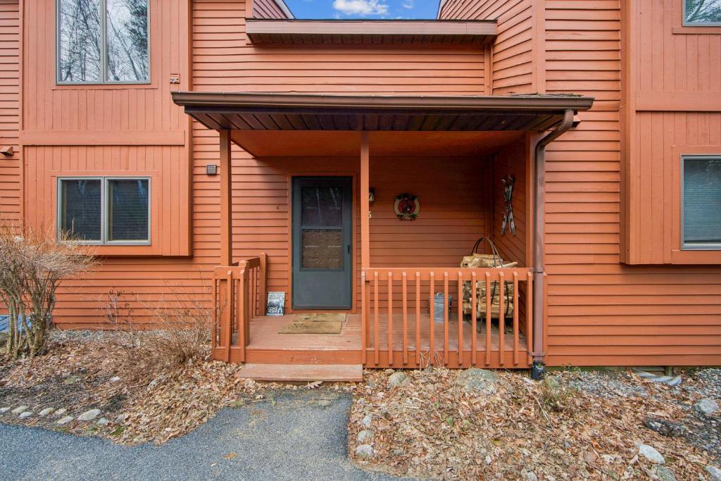a orange house with a door and a porch at Straight Brook 5D - Adirondack-Style Townhome in North Creek