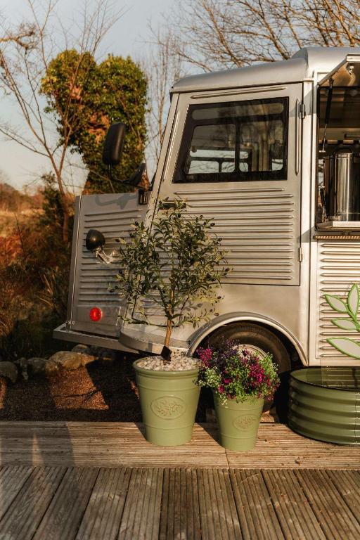 a truck with two potted plants in front of it at RiverBeds - Luxury Wee Lodges with Hot Tubs in Glencoe