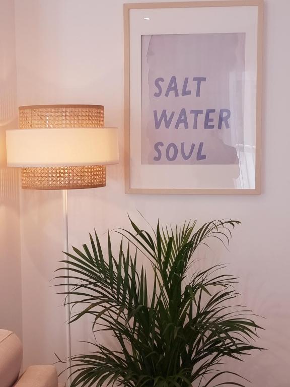 a plant in a living room with a picture and a lamp at Barra B Suite Apartment - 4min walk from BEACH, Terrace in Praia da Barra