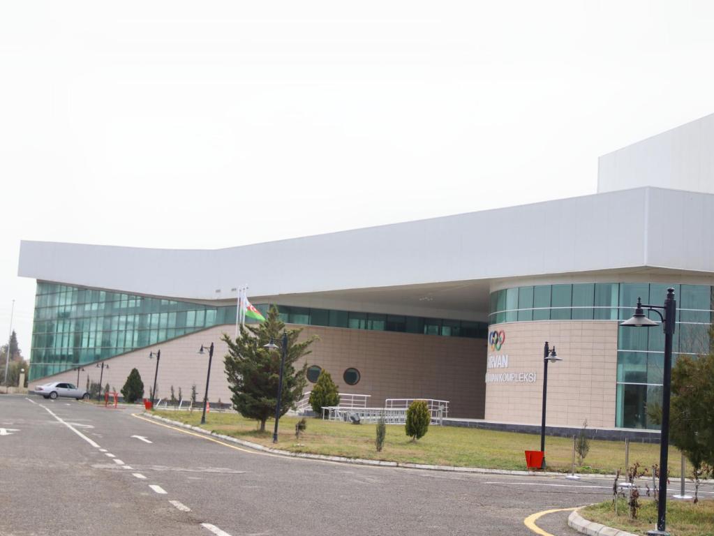 a parking lot in front of a large building at Arena Hotel Shirvan in Əli Bayramlı Stansiyası
