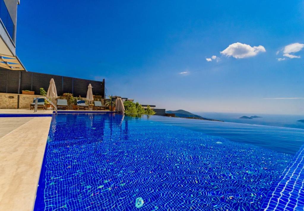 una gran piscina azul con vistas al océano en 4 Bedroom Sea View Villa in Kalkan, en Kas