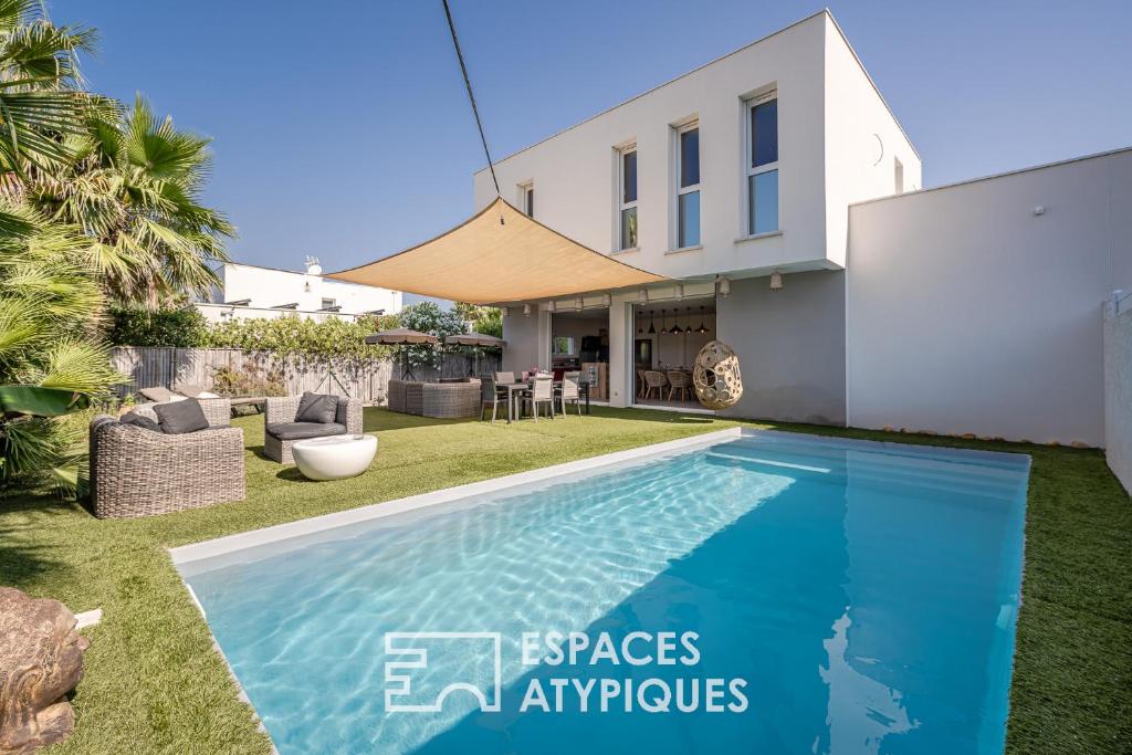 a villa with a swimming pool and a house at Villa proche plage mer, piscine grand terrain Capao Hotel in Cap d'Agde