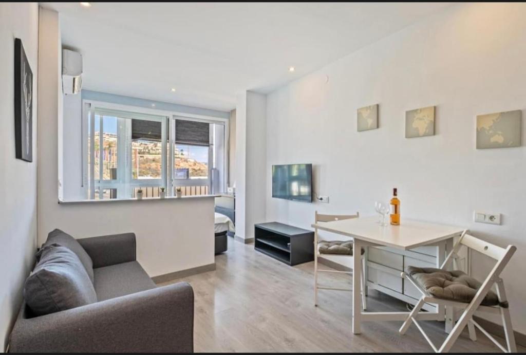 ein Wohnzimmer mit Sofa und Tisch in der Unterkunft Cala de Mijas Beach & Golf Studio in La Cala de Mijas