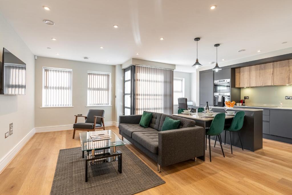 雷丁Bond House by Celador Apartments的客厅以及带沙发和桌子的厨房。