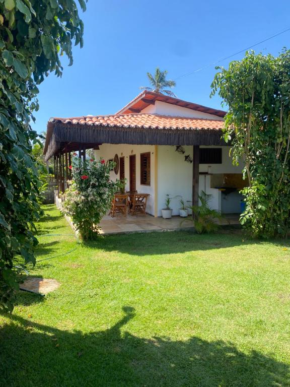 a small white house with a grass yard at Casa Girasol in Trairi
