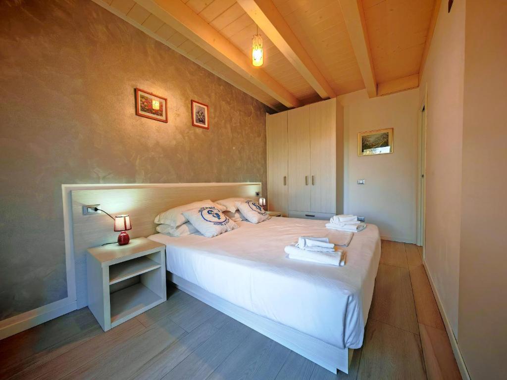 a bedroom with a white bed and a night stand at SG Luxury - Crystal Bay Apartment in Ronchi