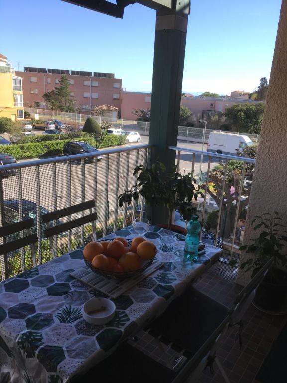 - une table avec un bol d'oranges sur un balcon dans l'établissement Venus 15, à Fleury