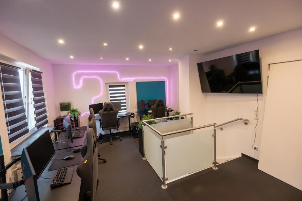 an office with purple lights on the walls and desks at World of Esport in Bayreuth