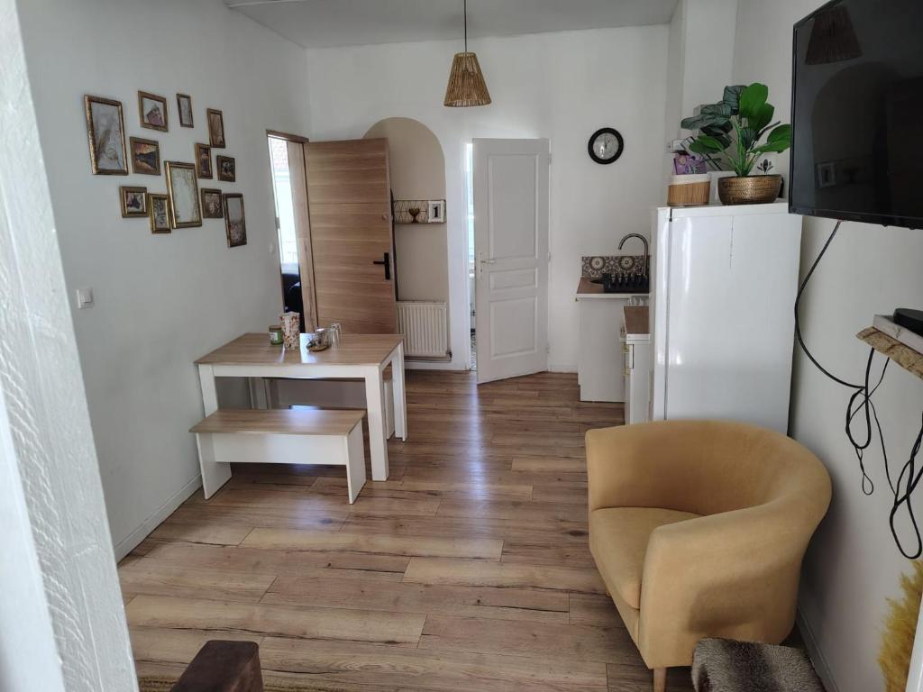 ein Wohnzimmer mit einem Tisch und einem weißen Kühlschrank in der Unterkunft Appartement au premier étage in Bourbourg