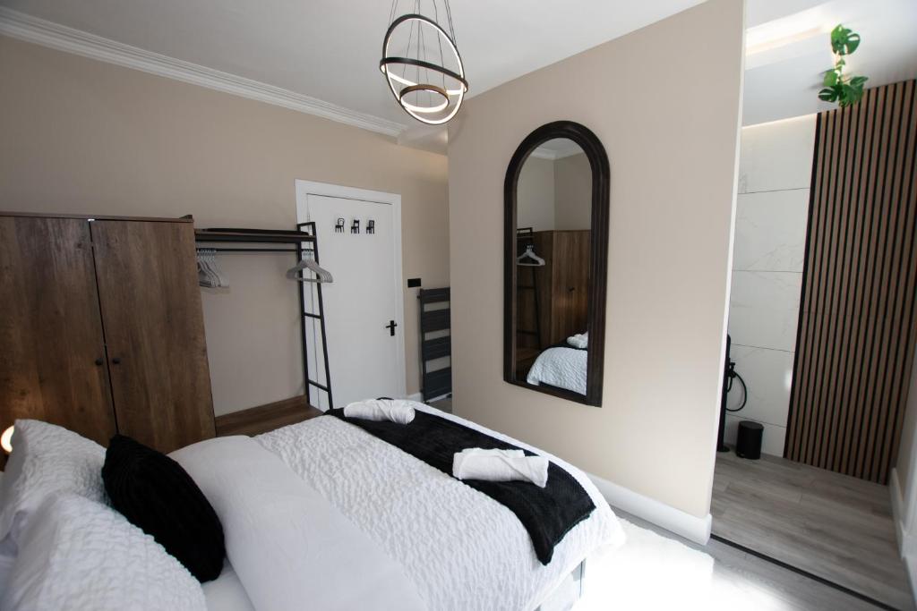 a bedroom with a white bed and a mirror at The White House near Edinburgh in Bathgate