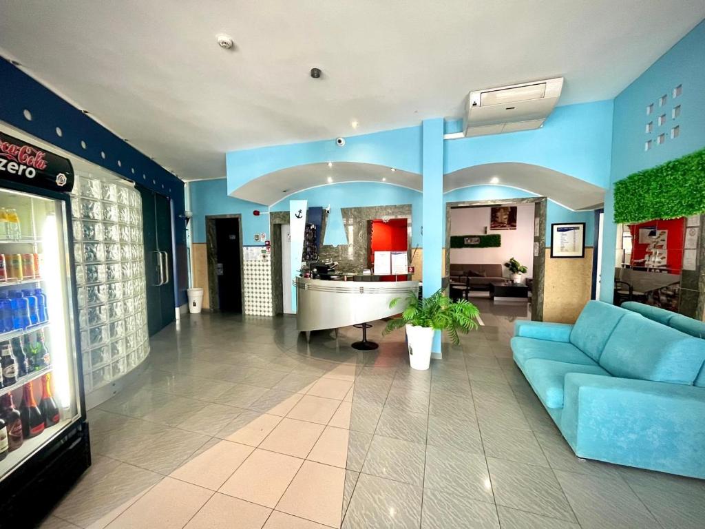 salon z niebieską kanapą w budynku w obiekcie Hotel Adria Mare w Rimini