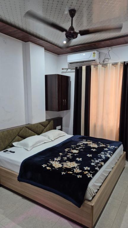 a bedroom with a bed with a black and white blanket at Baba Shyam hotel in Rīngas