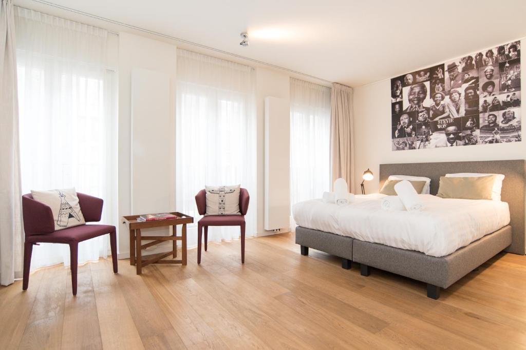 a bedroom with a bed and a table and two chairs at Apartments Grote Bickersstraat in Amsterdam