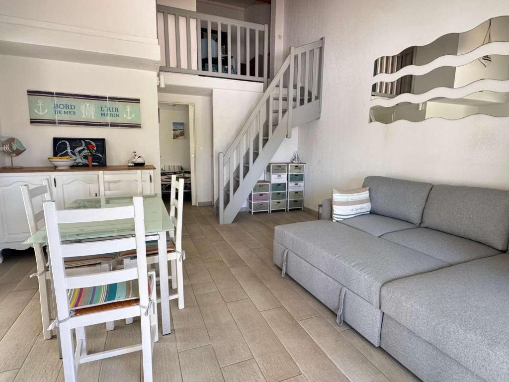 un salon avec un canapé et une table dans l'établissement T3 en Rez-de-Jardin avec Piscine, Parking, Clim et Proche Mer à Agde - FR-1-607-58, au Cap d'Agde