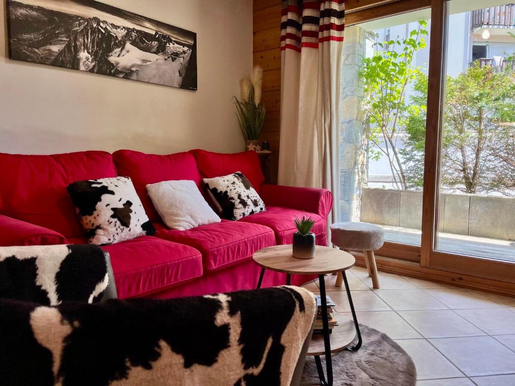 un canapé rouge dans un salon avec une fenêtre dans l'établissement Superbe appartement 48m² avec terrasse, centre village, parking, proche ski-bus, non-fumeur - FR-1-624-46, à Samoëns