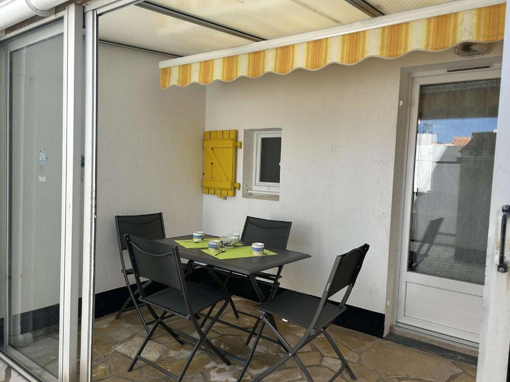 une table et des chaises assises sur une terrasse dans l'établissement Maison 3 pièces, piscine chauffée, proche mer - FR-1-224A-71, à Bretignolles-sur-Mer