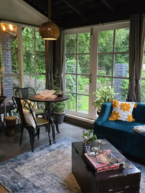 a living room with a blue couch and a table at The Owls Nest Farm in Dharmsāla
