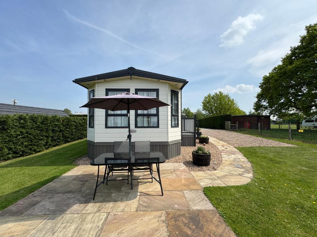 SkipwithにあるField House Farm - Owl Lodge - countryside stay near Yorkの小さな家(テーブルと傘付)