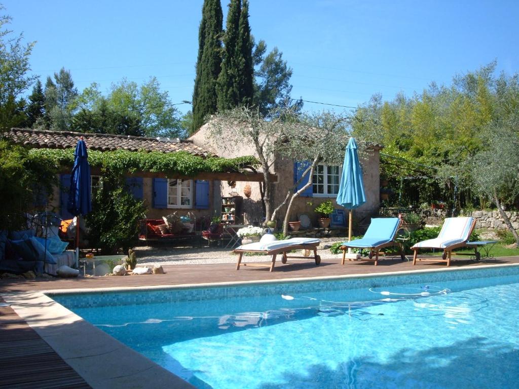 - une piscine avec 2 chaises longues et 2 parasols dans l'établissement Il bambù, à Valbonne