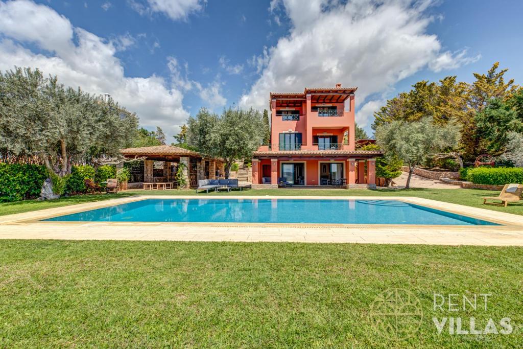 a house with a swimming pool in front of a house at Mariza Luxury Villa With Pool by goutos properties in Porto Heli