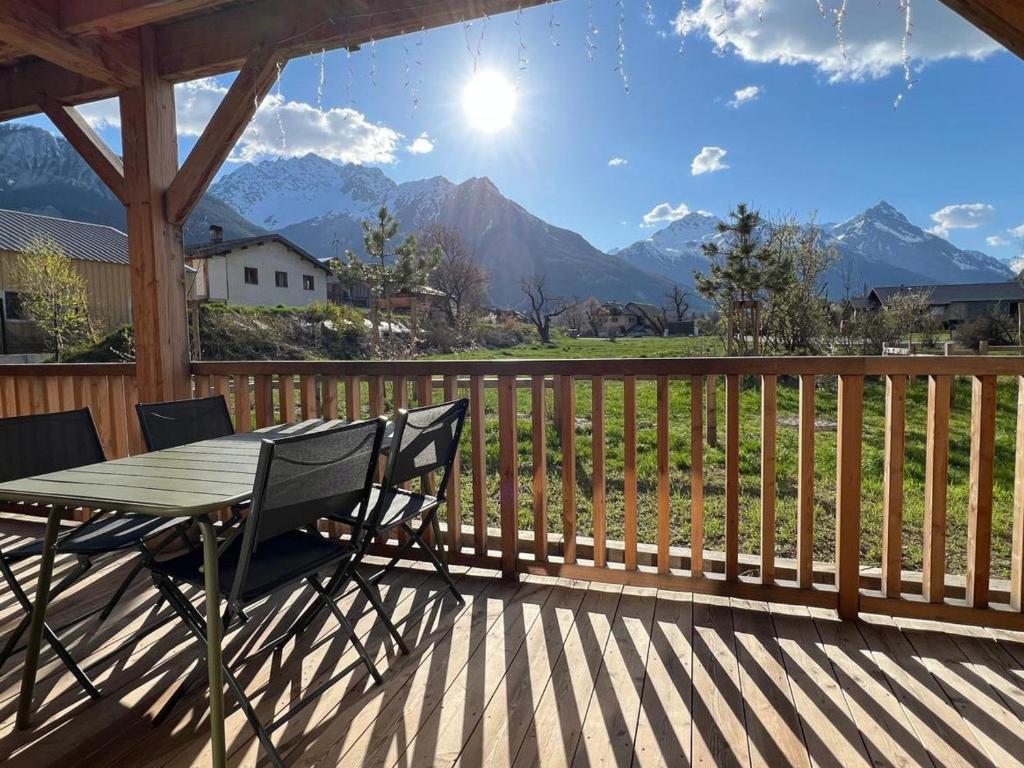 - une table et des chaises sur une terrasse avec vue sur les montagnes dans l'établissement Appartement 3 Pièces, 6 Pers., Terrasse, Jardin, Parking, Proche Pistes et Navette, Serre Chevalier - FR-1-762-51, au Monêtier-les-Bains