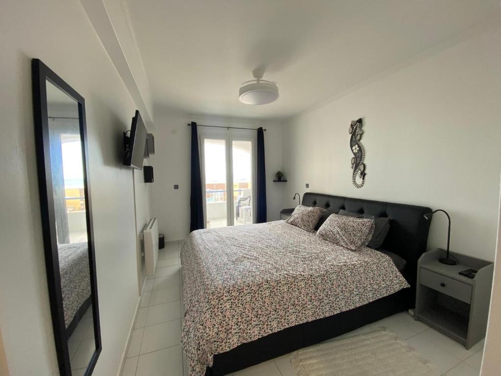 a bedroom with a bed and a large mirror at Apartamento na Praia in Vieira de Leiria