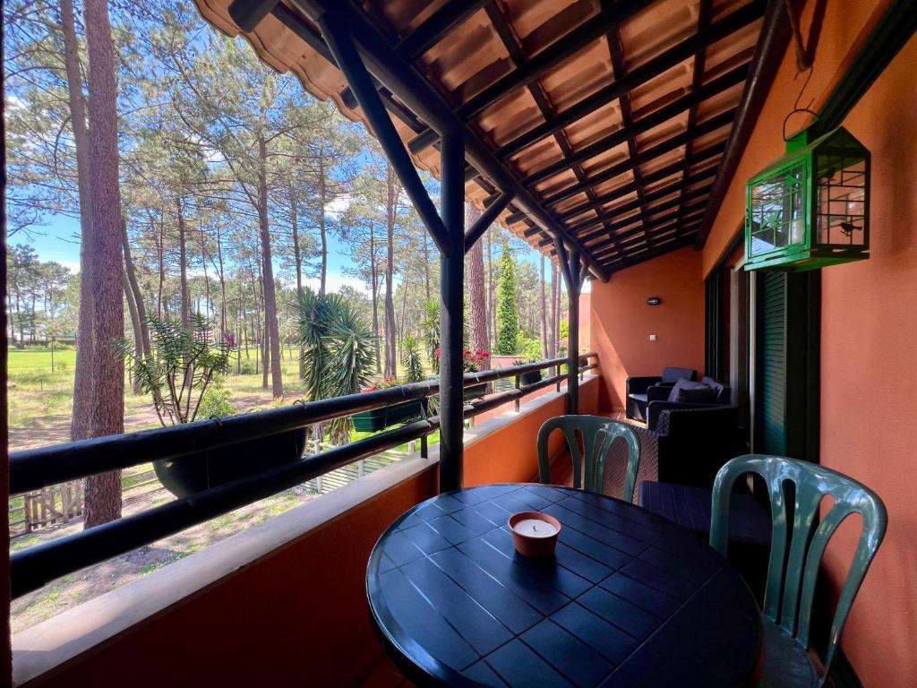 a table and chairs in a room with a window at Golf and Beach Serenity in Aroeira