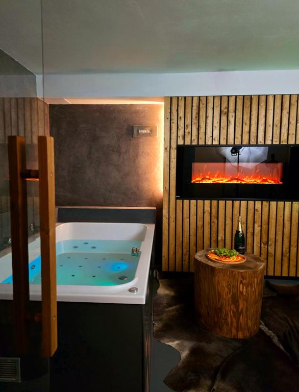 a bath tub in a room with a fireplace at Wellness Plus in Hrabŭvka