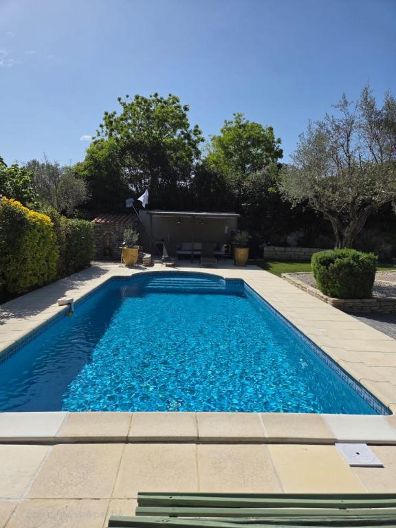 une piscine avec de l'eau bleue dans une cour dans l'établissement Les Mésanges, à Castelnau-le-Lez