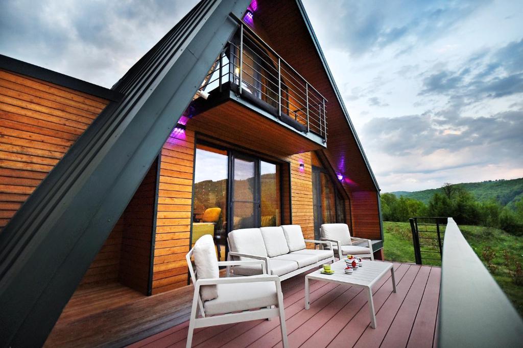Casa con terraza con sillas y mesa en Green Kub, en Slănic-Moldova