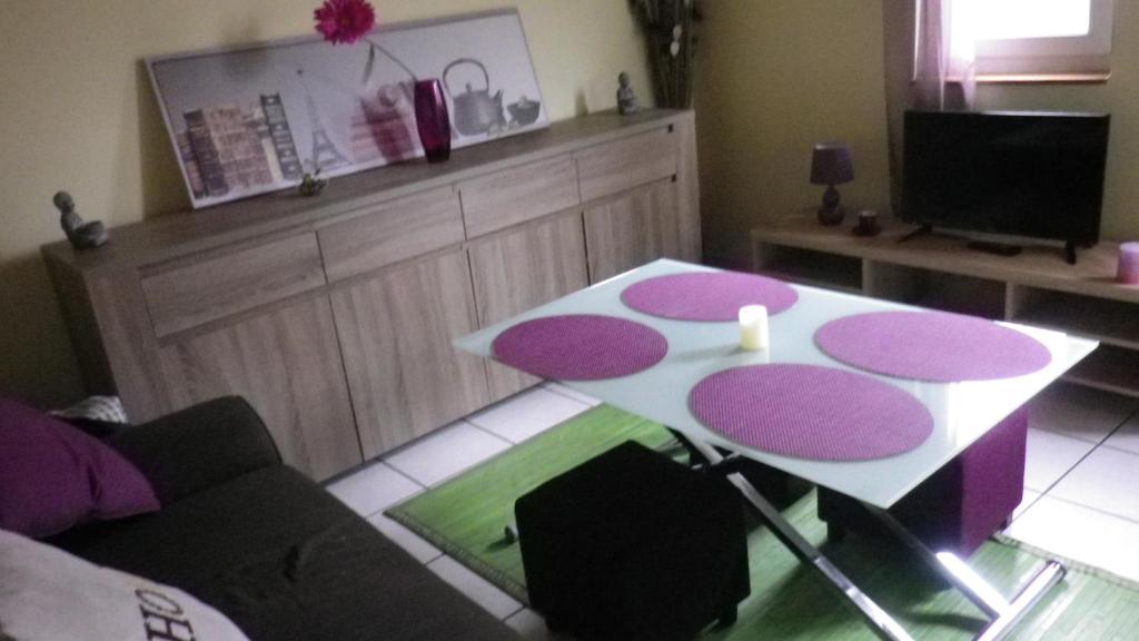 uma sala de estar com uma mesa e um sofá em Chez Fa et Pascal em Lanester