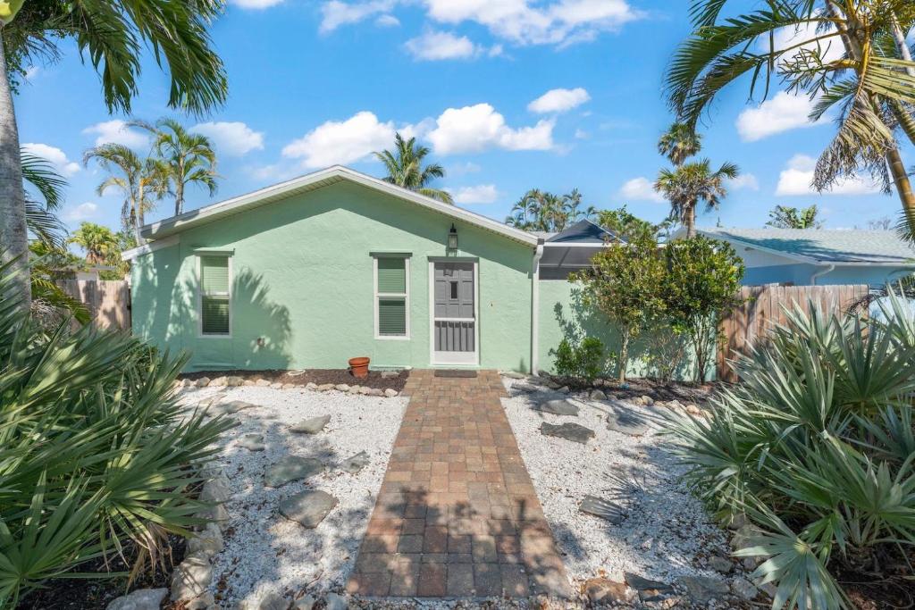 a green house with palm trees in front of it at Tipsy Turtle in Sanibel