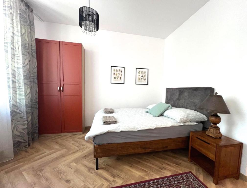 a bedroom with a bed and a red door at Zamojska Residence Silver Leaf Apartment in Lublin