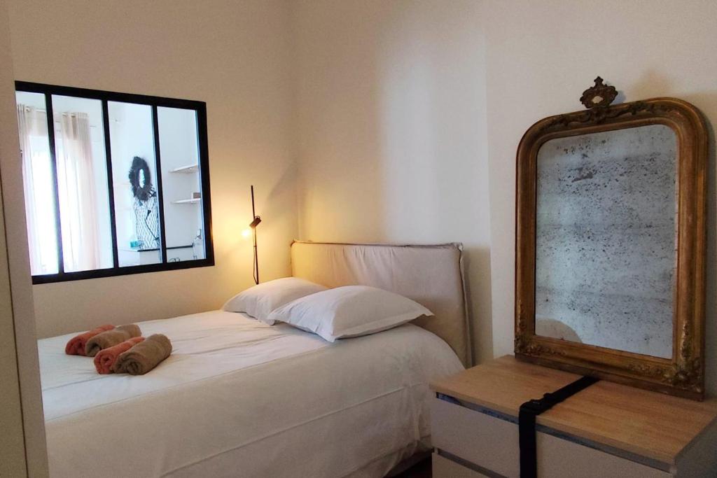 - une chambre avec un lit et un miroir dans l'établissement Apartments near Basilique Saint-Michel Bordeaux, à Bordeaux
